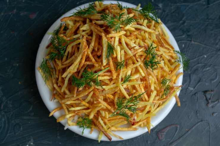 Final salad assembly Anthill salad completely covered in fried potatoes and dill