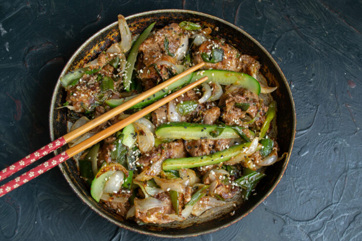 Serving the Warm Liver Salad Warm Korean-style chicken liver salad served with traditional chopsticks