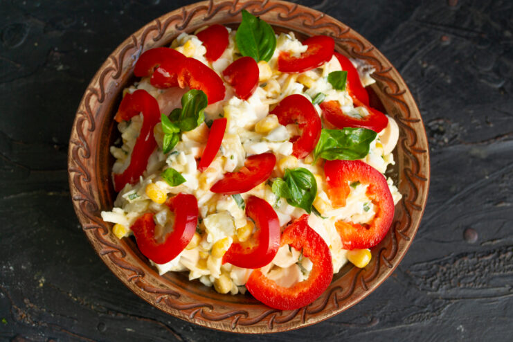 Final garnish Salad garnished with red bell pepper rings in a bowl.