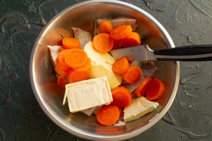 Vorschmack ingredients Herring, butter, carrots, and processed cheese in a bowl