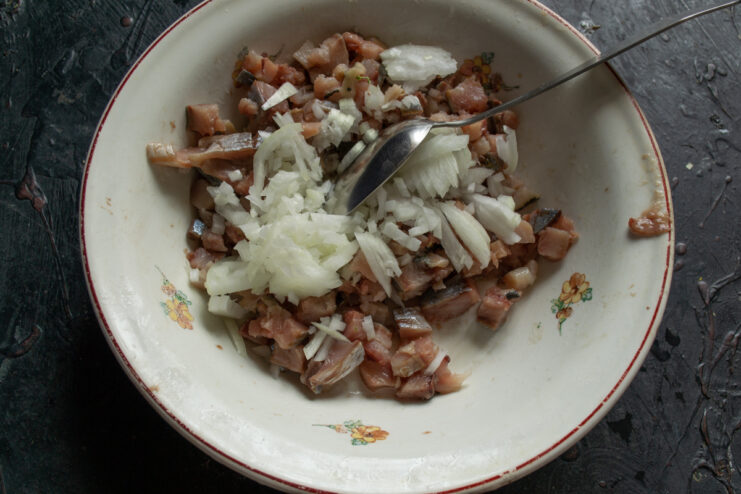 Herring and onion base Chopped herring mixed with diced sweet onion and mayonnaise in a bowl