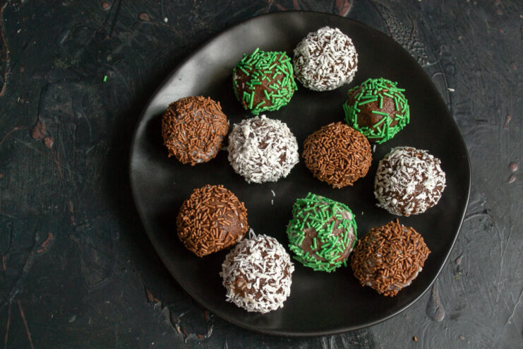 Plated chocolate petits fours on a black serving dish.
