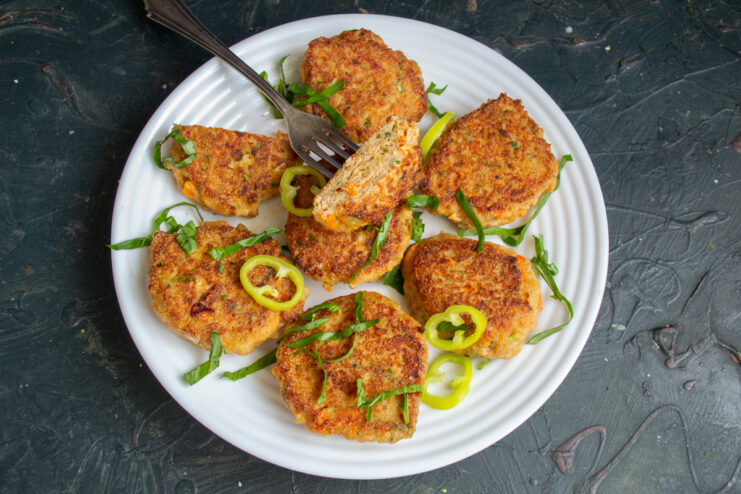 Plated salmon patties garnished with pepper rings and herbs