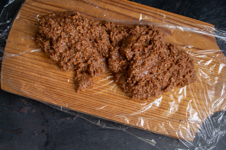 Shaping the salami Thick chocolate mixture placed on plastic wrap ready to be rolled into a log