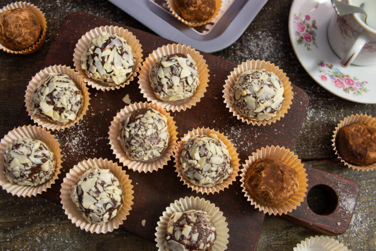 Homemade dark chocolate truffles with almonds and raisins arranged in small paper cups