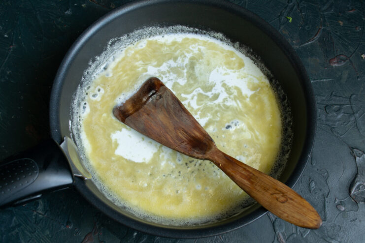 Adding the heavy cream Creamy sauce thickening in a hot skillet