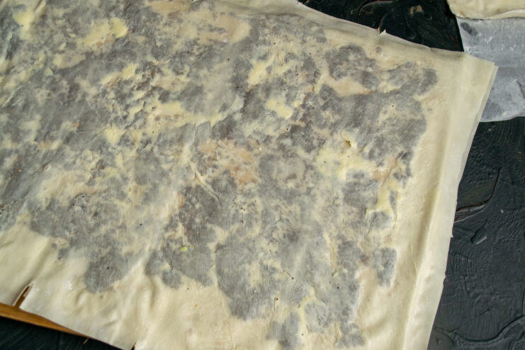 Layering the Dough Layers of phyllo dough brushed with melted butter