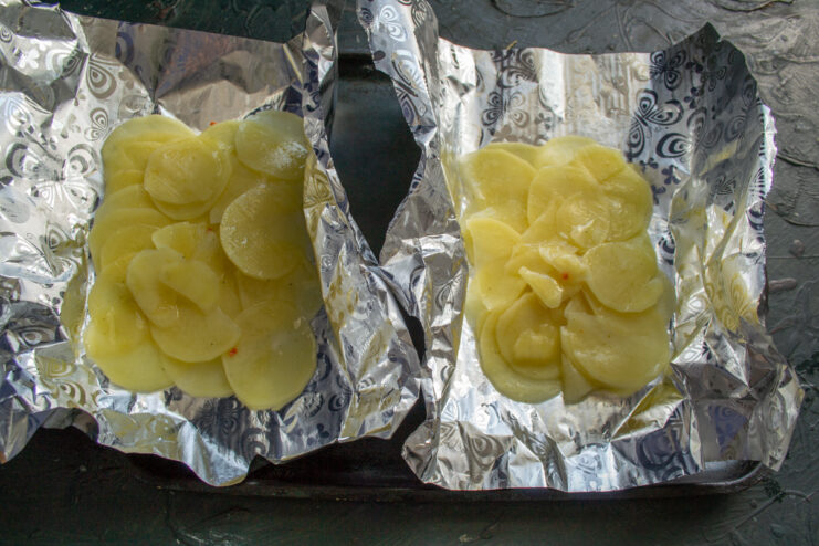 Forming the base Overlapping potato slices laid out on aluminum foil