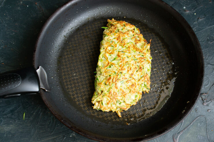 Final cooking Frying a folded zucchini pocket in a pan.