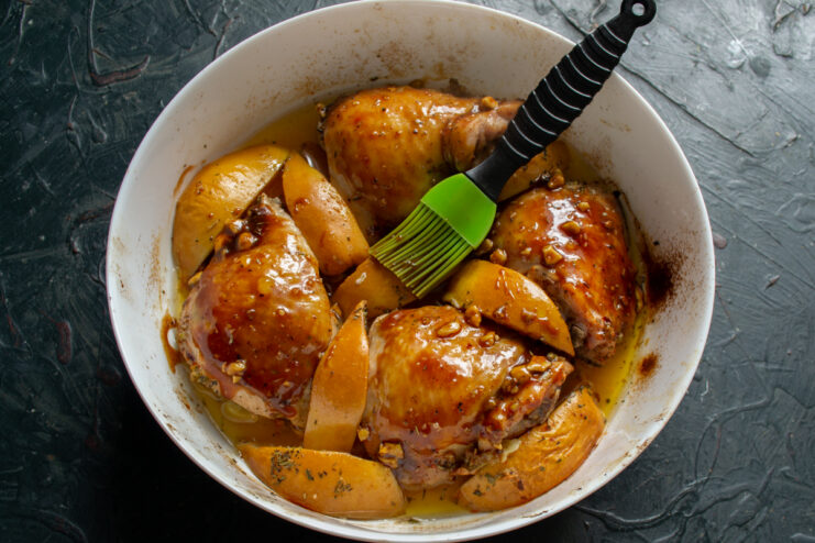 Applying The Glaze Brushing chicken with honey nut glaze using a silicone brush