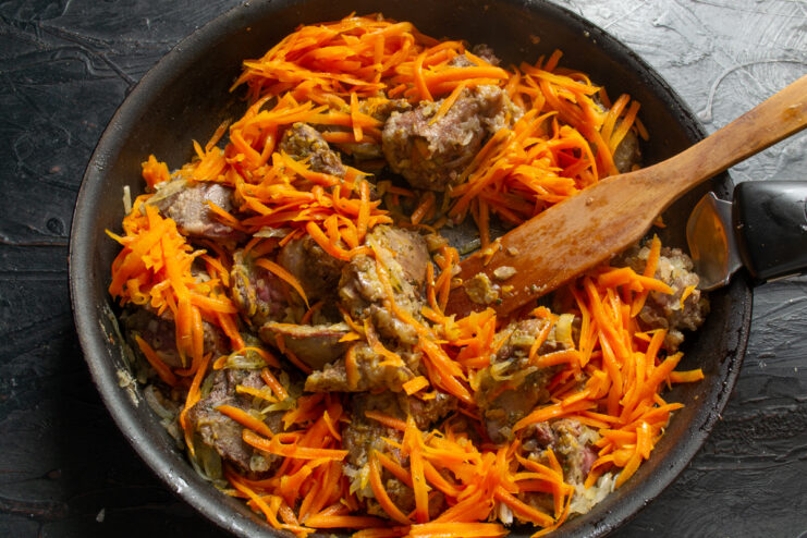 Simmering the pate base Chicken liver, onion, and grated carrot mixture simmering gently in a pan.