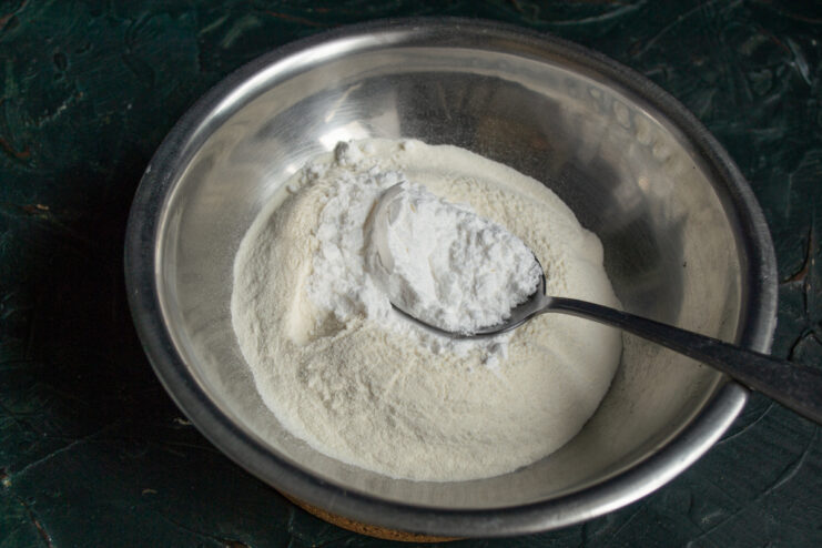 Preparing Dry Ingredients Mixing flour with powdered sugar and vanilla in a bowl