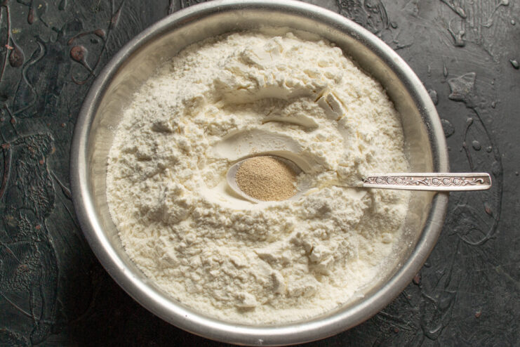 Preparing the dry ingredients Mixing extra-fine wheat flour and instant dry yeast in a metal bowl