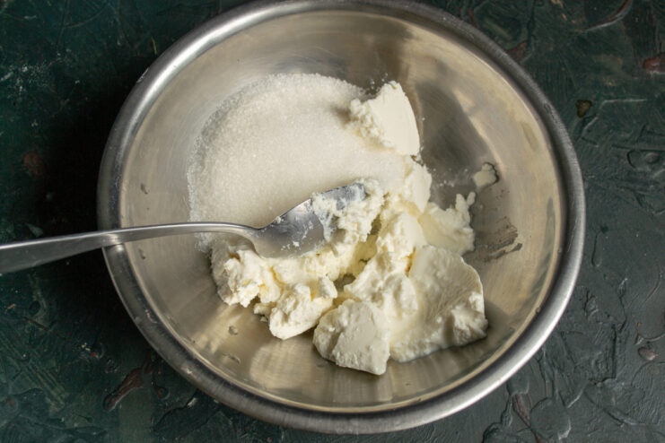 Preparing the ricotta filling Mixing ricotta cheese and sugar in a bowl for the tart filling