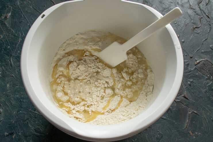 Pouring wet ingredients into the dry flour mixture