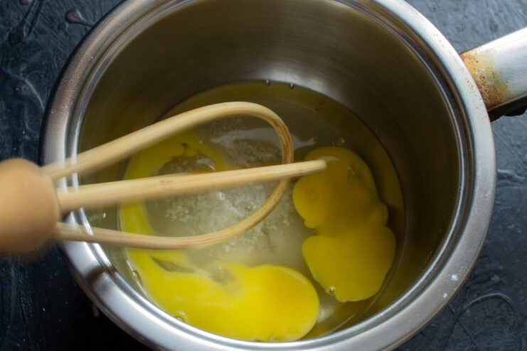 Whisking eggs, sugar, and salt together in a bowl