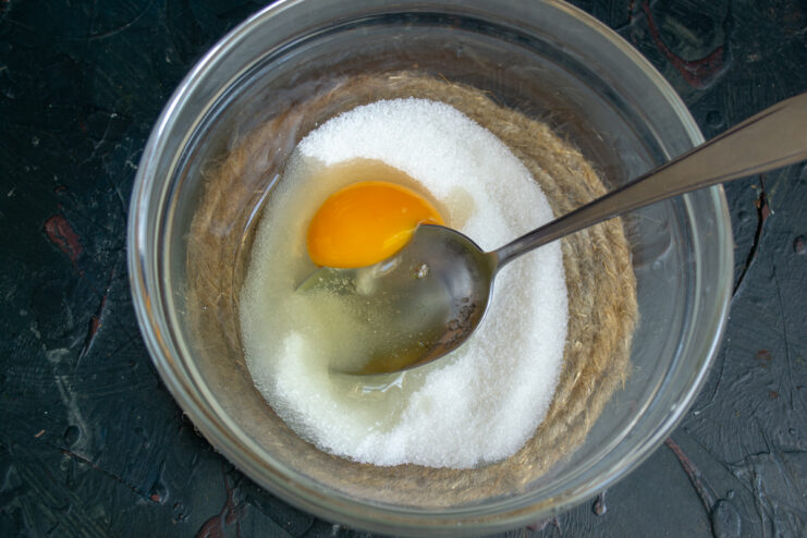 Mixing egg, sugar, and salt in a glass mixing bowl