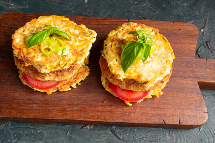 Final garnishing of the fishburgers Assembled healthy flourless fishburgers on a wooden board