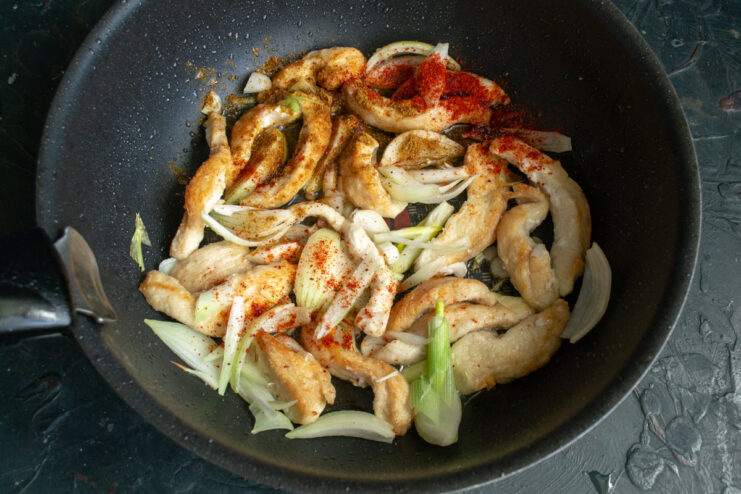 Seasoning the ojakhuri Sprinkling khmeli suneli and smoked paprika over the chicken