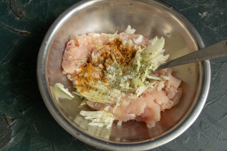 Adding paprika, pepper, and oil to season the chicken fillet