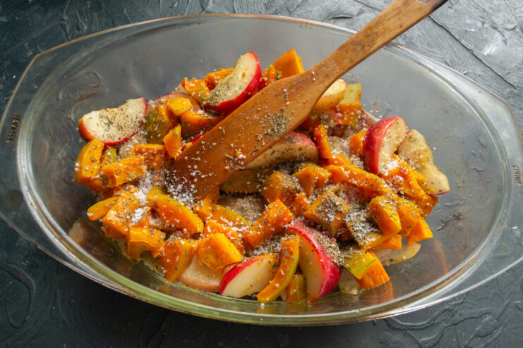 Adding seasonings Spices and salt sprinkled over the layers of meat and vegetables