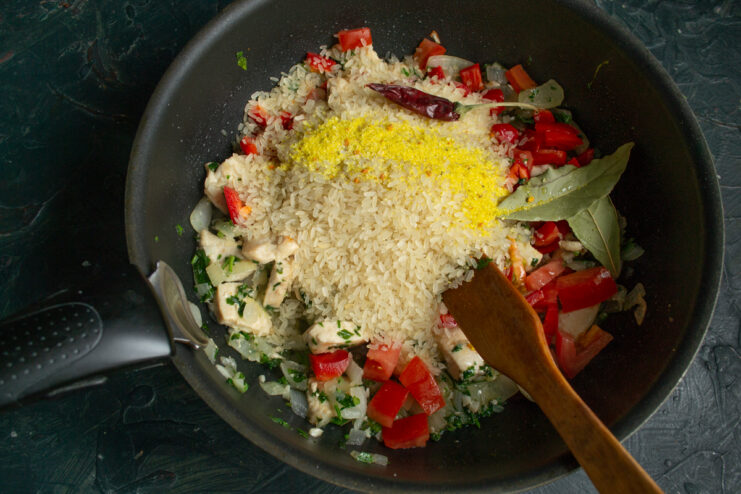Adding spices and a whole chili pepper on top of the rice mixture