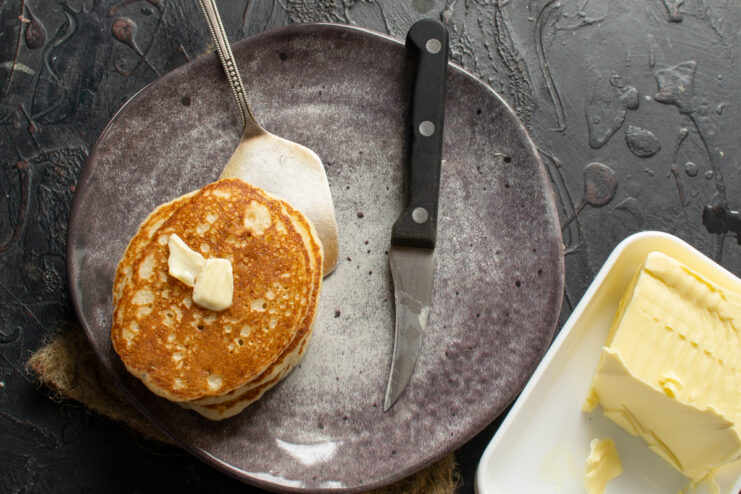 Stack of hot pancakes with a melting pat of butter on top