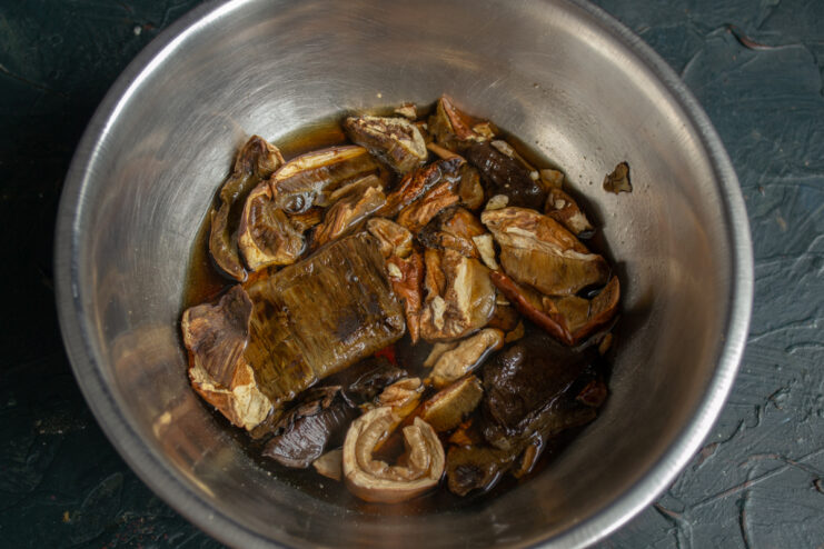Rehydrating the Mushrooms Dried porcini mushrooms soaking in a bowl of hot water.