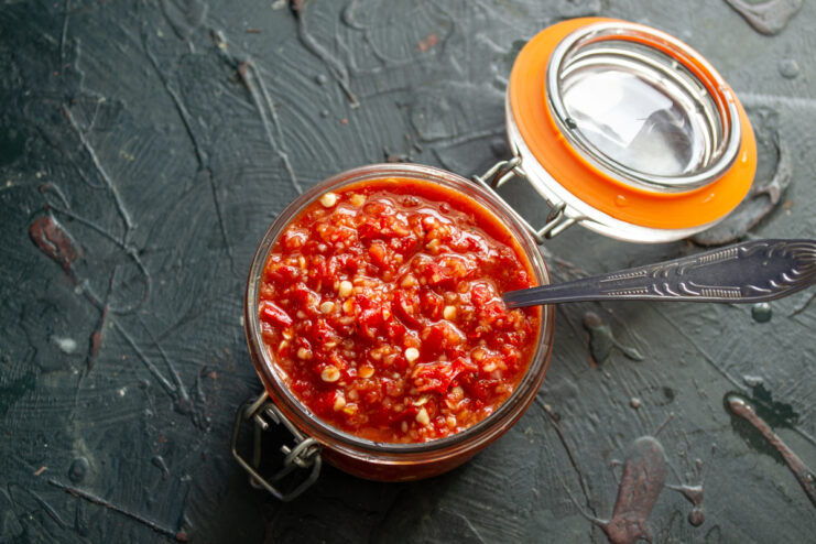 Storing the Raw Adjika Freshly prepared vibrant red adjika in a sealed glass jar with an orange gasket.
