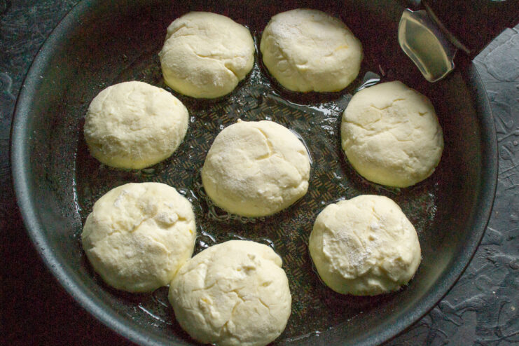 Syrniki frying in hot vegetable oil in a skillet