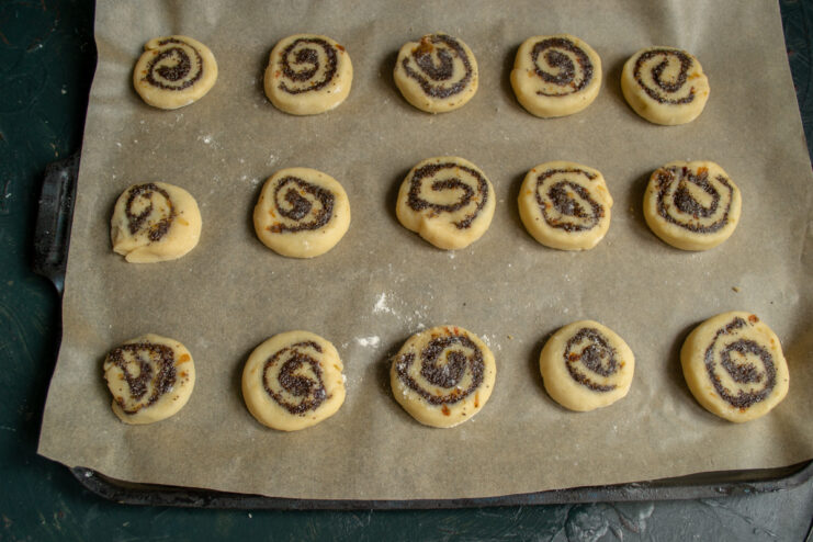 Arranging for Baking Raw poppy seed cookies arranged on a parchment-lined baking sheet