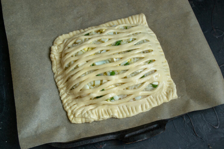 Unbaked lattice pie on a parchment-lined baking sheet