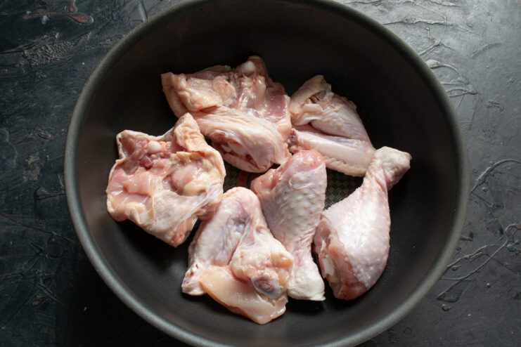 Searing the Chicken Raw chicken pieces in a deep skillet