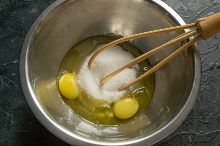 Combining eggs and sugar Raw eggs and granulated sugar in a mixing bowl