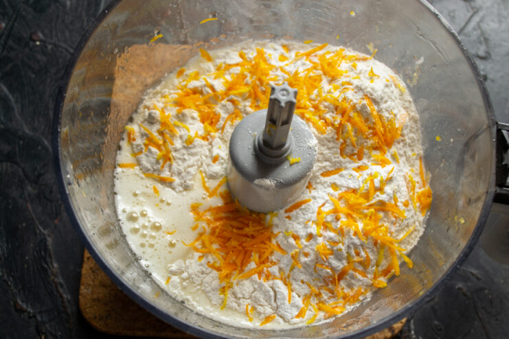 Adding orange zest Grated orange zest on top of the flour