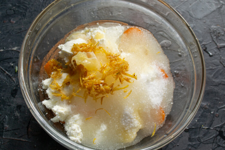 Adding lemon zest Freshly grated lemon zest over the fruit and farmers cheese mixture
