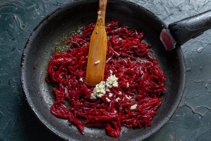 Braising the beet mixture Grated beets simmering with garlic in a skillet