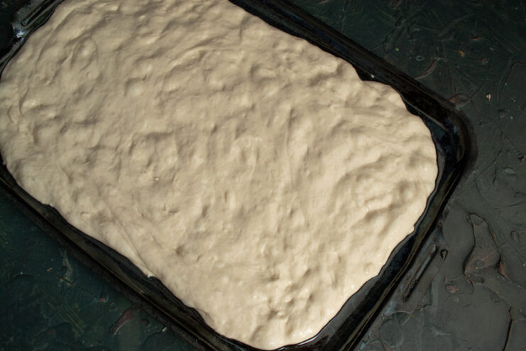 Shaping the flatbread Dough stretched into a rectangle on a baking sheet