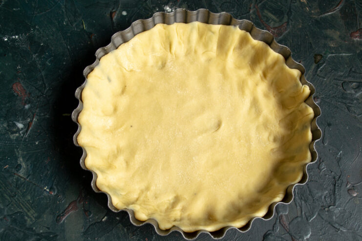 Pastry base in the pan Fitted pastry dough inside a fluted tart pan ready for chilling
