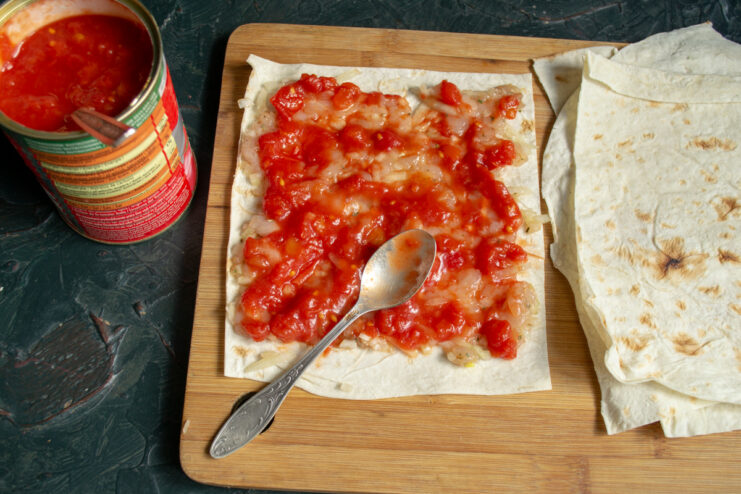 Layering chopped tomatoes over the ground meat for juiciness
