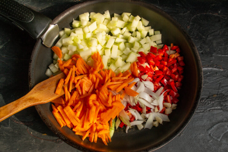 Thinly sliced carrots added to the vegetable mix in the skillet.