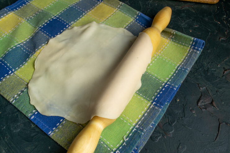 Thinly rolled dough draped over a rolling pin
