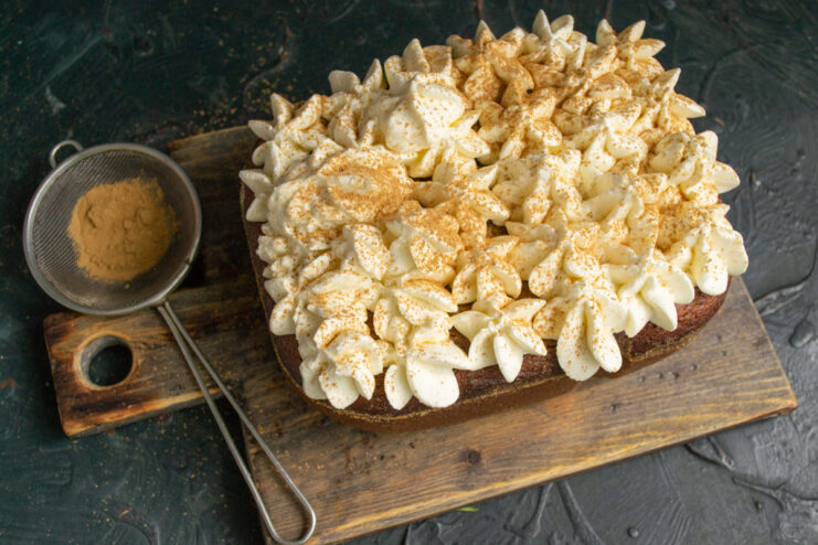Dusting With Cinnamon Dusting the whipped cream cake topping with ground cinnamon using a fine sieve