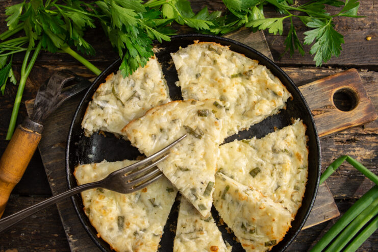 Zucchini and scallion farmer's cheese casserole on a rustic background
