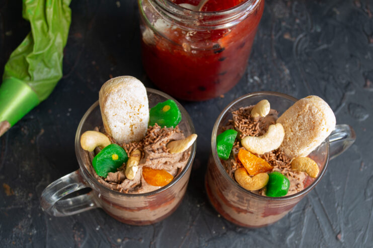 Garnishing the chocolate dessert with toasted cashews and candied kumquats.