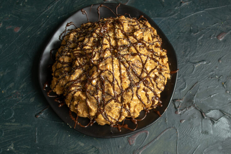 Decorating the cake Decorating shaped cake with a drizzle of melted chocolate and poppy seeds