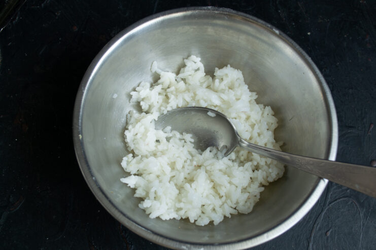 Cooked white rice resting in a metal mixing bowl