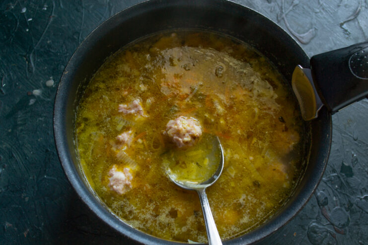 Cooking the meatballs Cooking meatballs in a boiling vegetable soup