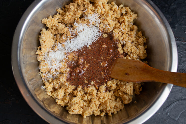 Adding the chocolate syrup Pouring creamy chocolate syrup into a bowl of crushed cookies and nuts