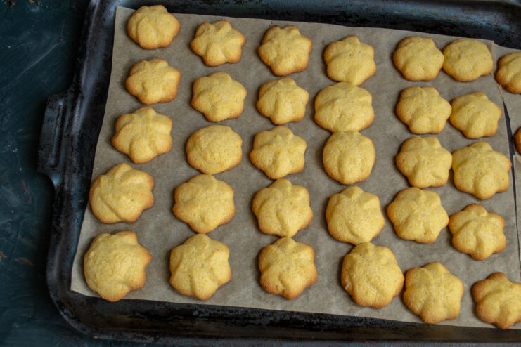 Baking the cookies Freshly baked golden polenta cookies resting on a baking sheet.